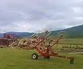 Wheel-finger rake (in folded transport position) for raking hay or straw into windrows for picking up from them by the baler