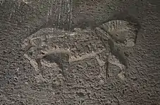 Large low-relief depiction on the interior side of the stone lintel above the entry.
