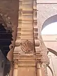 A palmette/seashell motif carved into the arches near the qibla wall