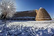 The twin Yakhchāls of Sirjan, Kerman Province, with arched shade wall inbetween