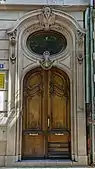 Wooden door with a round window above it, in Strasbourg