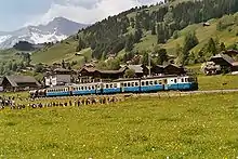 Metre-gauge electric twin motor coach ABDe 8/8 4004 of the MOB in Switzerland pulling two coaches and two cement wagons