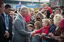 Charles shaking hands with a crowd in New Zealand in 2015