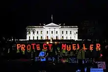 Demonstrators hold up red-lit letters that read PROTECT MUELLER in front of the White House