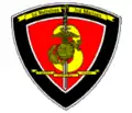 A black shield with a red interior. On the top is written "Third Battalion Third Marines". The red interior has a "3" in the center with a sword running through it and an Eagle Globe and Anchor with the words "Fortes Fortuna Juvat" in the center.