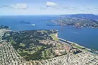 Aerial view of the Golden Gate Bridge connecting the wooded Presidio to the hilly Marin Headlands