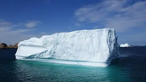 An iceberg floating at the mouth of the fjord; southern end