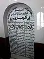 Gravestone with date of death and lines in Persian language.