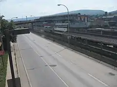 An Eastbound Pennsylvanian stops at Altoona as seen from the pedestrian overpass above 10th Ave.  Note just above the streetlight cowling, the gap in the fence at the site of the old temporary station.