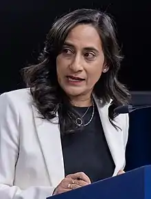 Close-up photograph of a woman speaking into a microphone