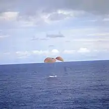 Spaceship contacts ocean under parachute