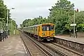 A Merseyrail Class 507 arrives with a service from Liverpool.
