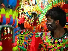 A man in a colorful costume, his face painted
