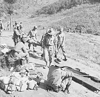 Soldiers carrying a man on a stretcher.