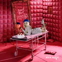 Max is positioned on top of a stretcher with a cake while holding a knife. The song title is written on the mirror behind her inside of a red room.