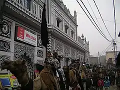 Children on camels in front of Azakhana or Hussainia Juloos in Amroha, India.