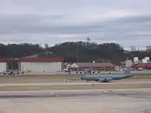 A KC-135R Stratotanker departing with the Alabama Air National Guard hangars and buildings behind.