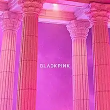 A pink to purple picture of four corinthian orderd pillars and the Black Pink logo in the center.