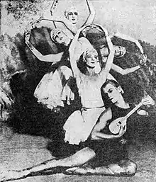 Five dancers pose in front of a forested backdrop
