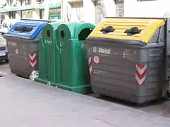 Colour-coded kerbside bins for recycling (left to right) paper, glass, and plastic, Barcelona, Spain