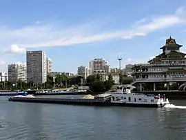 Alfortville and Chinagora, with a barge and tugboat on the River Seine