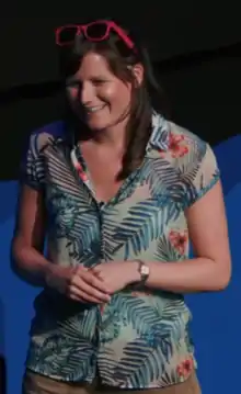 Smethurst smiling and presenting with sunglasses on top of her head