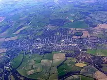 aerial picture of the town surrounded by green fields.