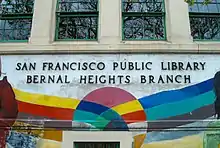 A colorful mural painted on the sign of the Bernal Heights Branch Library