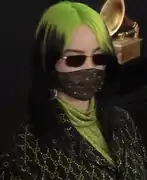 2020: Singer Billie Eilish sporting a face mask and mix of brown- and green-dyed straight hair.
