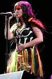 Björk is holding a mic in her right hand.