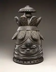 Helmet mask (ndoli jowei) for Sande society; late 19th-early 20th century; wood; 39.4 x 23.5 x 26&nbsp;cm (15.mw-parser-output .frac{white-space:nowrap}.mw-parser-output .frac .num,.mw-parser-output .frac .den{font-size:80%;line-height:0;vertical-align:super}.mw-parser-output .frac .den{vertical-align:sub}.mw-parser-output .sr-only{border:0;clip:rect(0,0,0,0);clip-path:polygon(0px 0px,0px 0px,0px 0px);height:1px;margin:-1px;overflow:hidden;padding:0;position:absolute;width:1px}1⁄2 x 9.mw-parser-output .frac{white-space:nowrap}.mw-parser-output .frac .num,.mw-parser-output .frac .den{font-size:80%;line-height:0;vertical-align:super}.mw-parser-output .frac .den{vertical-align:sub}.mw-parser-output .sr-only{border:0;clip:rect(0,0,0,0);clip-path:polygon(0px 0px,0px 0px,0px 0px);height:1px;margin:-1px;overflow:hidden;padding:0;position:absolute;width:1px}1⁄4 x 10.mw-parser-output .frac{white-space:nowrap}.mw-parser-output .frac .num,.mw-parser-output .frac .den{font-size:80%;line-height:0;vertical-align:super}.mw-parser-output .frac .den{vertical-align:sub}.mw-parser-output .sr-only{border:0;clip:rect(0,0,0,0);clip-path:polygon(0px 0px,0px 0px,0px 0px);height:1px;margin:-1px;overflow:hidden;padding:0;position:absolute;width:1px}1⁄4 in.); Brooklyn Museum (New York City). A vertical crack runs from base of mask to head band at back center and includes a triangular 1.mw-parser-output .frac{white-space:nowrap}.mw-parser-output .frac .num,.mw-parser-output .frac .den{font-size:80%;line-height:0;vertical-align:super}.mw-parser-output .frac .den{vertical-align:sub}.mw-parser-output .sr-only{border:0;clip:rect(0,0,0,0);clip-path:polygon(0px 0px,0px 0px,0px 0px);height:1px;margin:-1px;overflow:hidden;padding:0;position:absolute;width:1px}3⁄4 hole below band