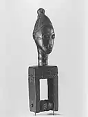 Heddle pulley with female head; late 19th or early 20th century; wood; 20.6 × 5.4 × 4.8&nbsp;cm (8.mw-parser-output .frac{white-space:nowrap}.mw-parser-output .frac .num,.mw-parser-output .frac .den{font-size:80%;line-height:0;vertical-align:super}.mw-parser-output .frac .den{vertical-align:sub}.mw-parser-output .sr-only{border:0;clip:rect(0,0,0,0);clip-path:polygon(0px 0px,0px 0px,0px 0px);height:1px;margin:-1px;overflow:hidden;padding:0;position:absolute;width:1px}1⁄8 × 2.mw-parser-output .frac{white-space:nowrap}.mw-parser-output .frac .num,.mw-parser-output .frac .den{font-size:80%;line-height:0;vertical-align:super}.mw-parser-output .frac .den{vertical-align:sub}.mw-parser-output .sr-only{border:0;clip:rect(0,0,0,0);clip-path:polygon(0px 0px,0px 0px,0px 0px);height:1px;margin:-1px;overflow:hidden;padding:0;position:absolute;width:1px}1⁄8 × 1.mw-parser-output .frac{white-space:nowrap}.mw-parser-output .frac .num,.mw-parser-output .frac .den{font-size:80%;line-height:0;vertical-align:super}.mw-parser-output .frac .den{vertical-align:sub}.mw-parser-output .sr-only{border:0;clip:rect(0,0,0,0);clip-path:polygon(0px 0px,0px 0px,0px 0px);height:1px;margin:-1px;overflow:hidden;padding:0;position:absolute;width:1px}7⁄8 in); Brooklyn Museum