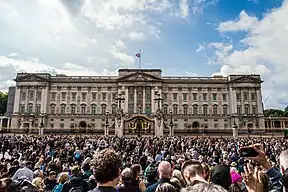 A crowd assembled outside of a large building