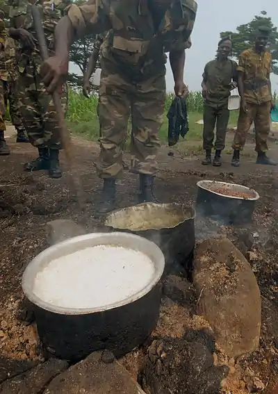 Bjumbura Burundi soldiers cooking in a sufuria over a fire