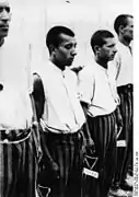 Black triangles visible on the trousers of Romani detainees at Dachau