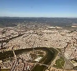 View centred on the city's historic core in relation to the Guadalquivir, with Sierra Morena in the background (November 2020)