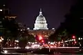 US Capitol Building lit up at night with the streets of Washington DC