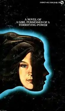 The cover art for the 1975 paperback edition. A teenage girl's face is partially obscured and facing forward. Behind her is a silhouette facing to the right, bordered with a blue light. Above the face is a tagline that says "A novel of a girl possessed of a terrifying power".