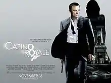 The poster shows Daniel Craig as James Bond, wearing a business suit with a loose tie and holding a gun. Behind him is a silhouette of a woman showing a building with a sign reading "Casino Royale" and a dark grey Aston Martin DBS below the building. At the bottom left of the image is the title "Casino Royale" – bothшп "O"s stand above each other, and below them is a 7 with a trigger and gun barrel, forming Bond's codename: "Agent 007" – and the credits.