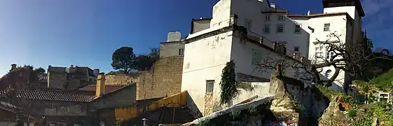 Fragmental cerca moura section at the east junction with citadel wall. The white tower (right), ochre wall section (left center), and tower on the skyline (left) are standing remnants.