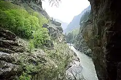 A river running through a narrow mountain valley with steep rocky slopes