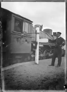 Changing the tablet at Horopito Railway Station, with an X class in 1920.