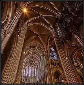 The vaults of the roof, connected by stone ribs to the pillars below, combined with the flying buttresses outside make possible thinner walls, and the great height and large windows of the cathedral