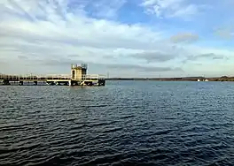 A large lake with a jetty and a water tower