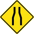 Road narrows ahead on both sides