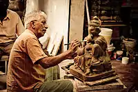 Man painting a statue of Ganesh
