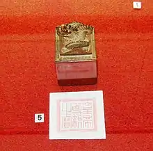 Imperial seal, decorated with a dragon, and its imprint against a red background
