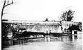 Destroyed aqueduct wall and canal boat in creek