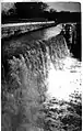 Damaged aqueduct, with water pouring out of the canal, in 1920.