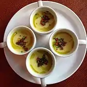 Cups of corn chowder with bacon, potato, olive oil and chives